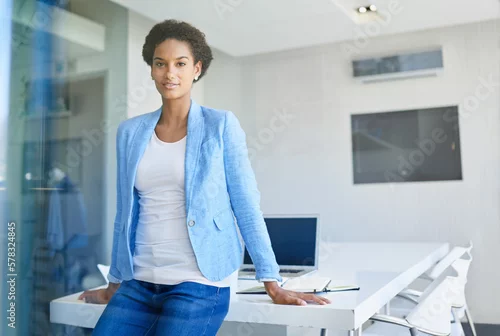 Obraz Shes the right woman for the job. Cropped portrait of an attractive young businesswoman leaning on her office desk.
