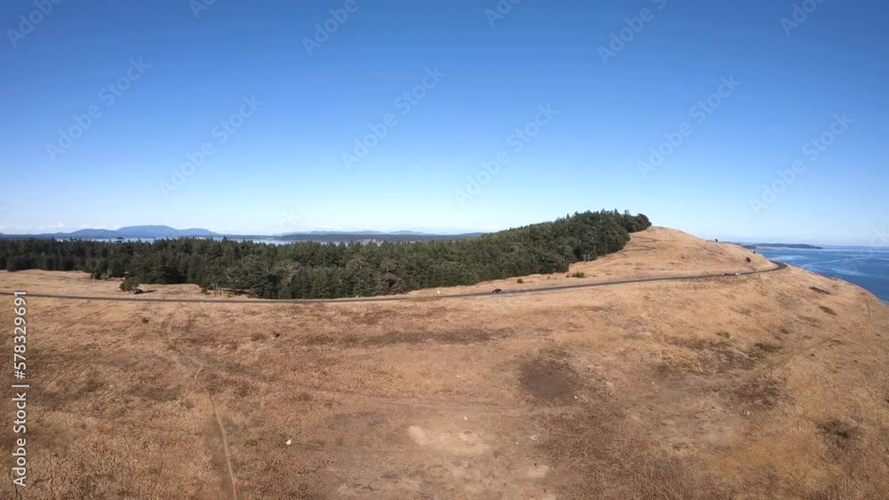 Drone flight over the beach. The sky is blue and the day is sunny. You can see the road and a car driving. Drone flight over the beach. The sky is blue and the day is sunny. You can see the road and a car driving.