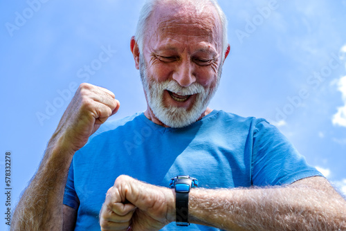 Portrait of a senior man checking his watch. The elderly sportsman controls his heart rate and blood pressure by monitoring the smartwatch on his wrist, happy with the results. Healthcare.