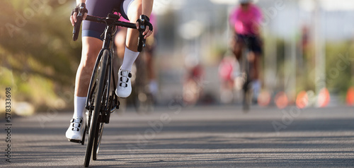 Female cyclist riding racing bicycle. Cycling competition, cyclist athletes riding a race 