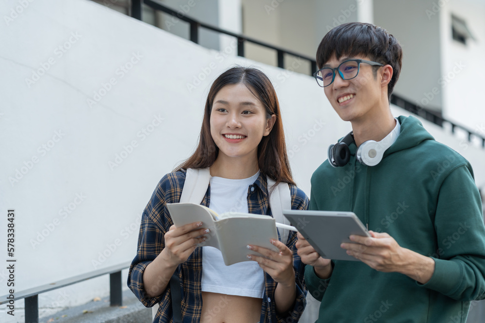 Two Asian students studied and researched together with laptop computers and journaling in an outdoor biological analogy at university. Two Asian students studied and researched together with laptop computers and journaling in an outdoor biological analogy at university.