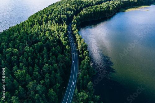 Obraz na płótnie Aerial view of road in green woods and blue lakes water in Finland w salonie