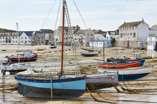 Isles of Scilly, United Kingdom - harbor of St. Mary´s at low tide with many boats on the sand and town in the background photo