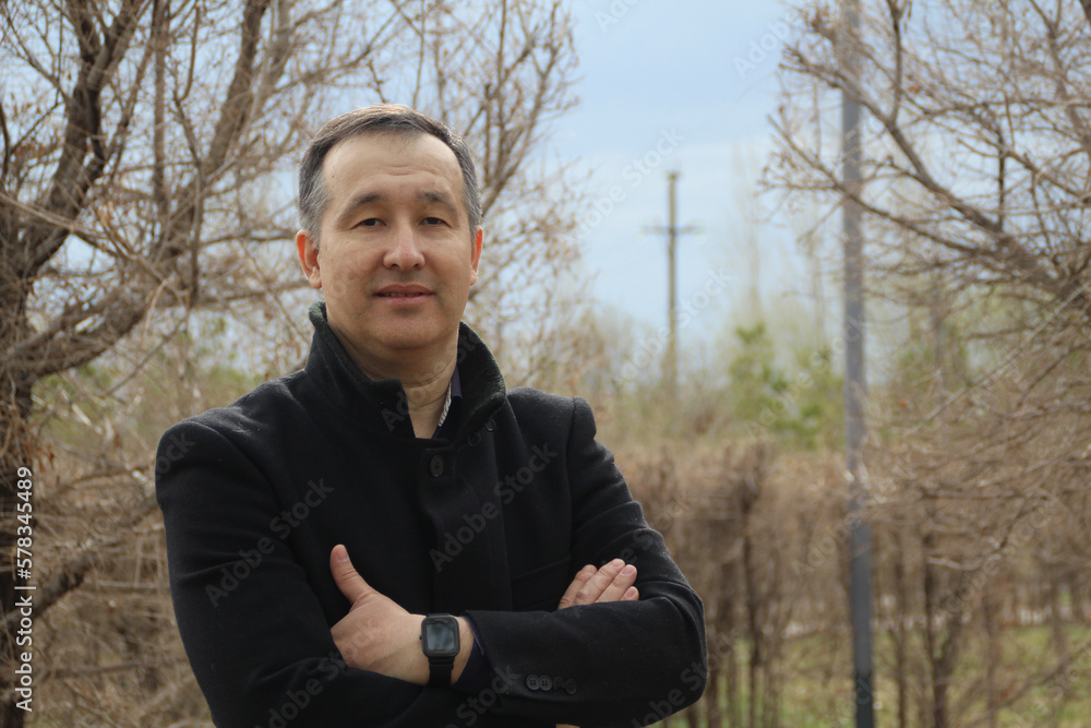 Middle-aged Asian man in a coat on a walk. Middle-aged Asian man in a coat on a walk.