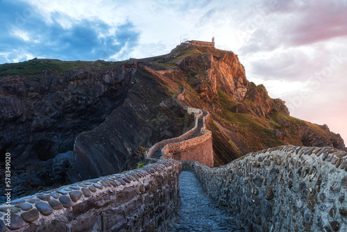 San Juan de Gaztelugatxe island with church at Basque country, Spain. Stone bridge with stairs leading to the rock photo
