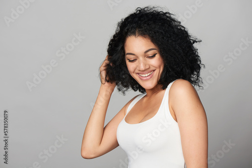 Happy playful smiling mixed race girl on grey background