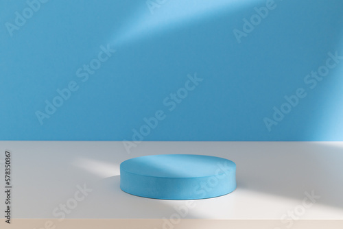 Round cylinder podium for products or cosmetics against light pastel blue background with geometric shadows.