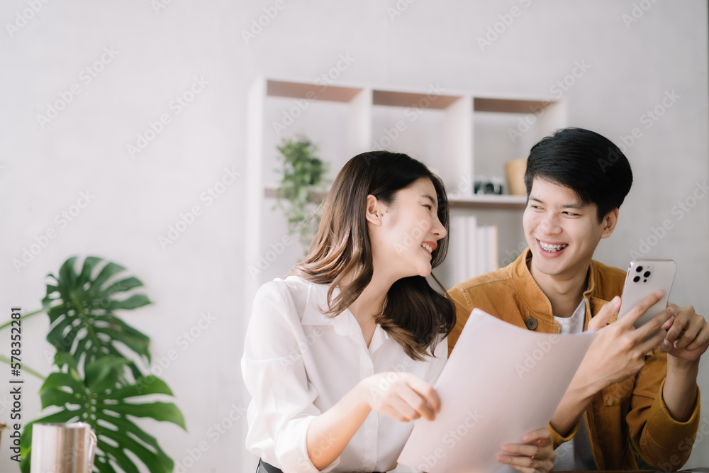 Happy asian young couple smile and looking to screen tablet with laptop at home the morning. Happy asian young couple smile and looking to screen tablet with laptop at home the morning.