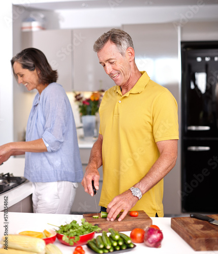 Sharing responsibilities in the kitchen. a mature couple preparing a meal together in the kitchen.