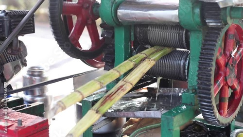 Video cropped hands using technic machine for sugarcane processing, juice production with rotating walk through element