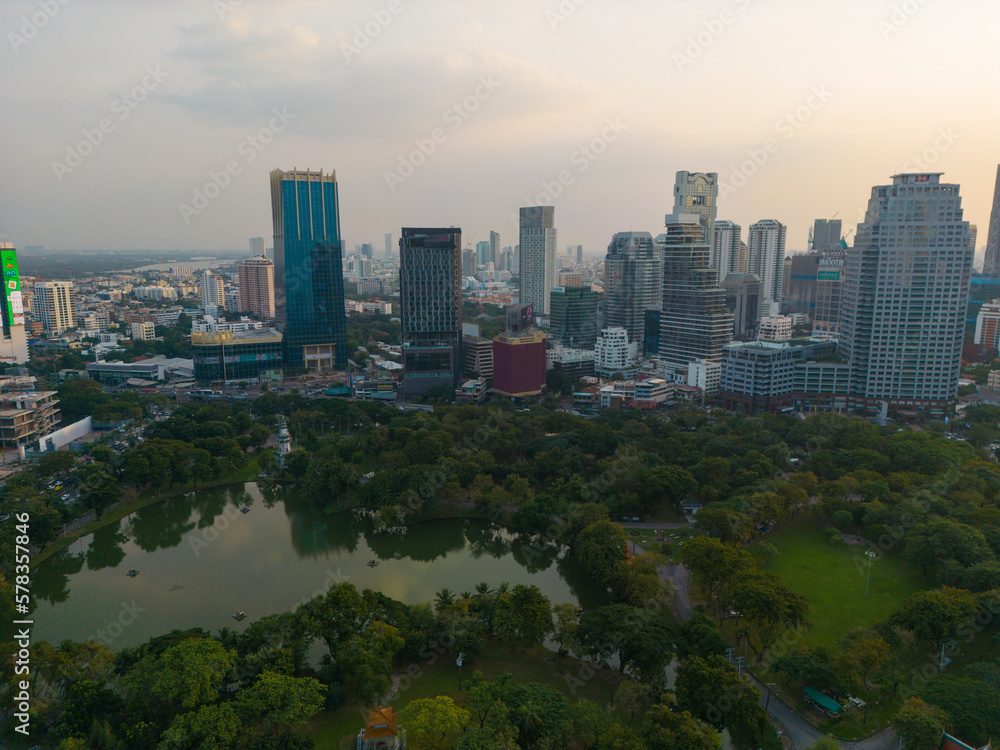 Obraz premium Aerial view Lumpini central park with modern office building sunset sky downtown