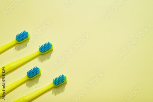 Modern yellow kids toothbrushes on a yellow background. Copy space for your text 