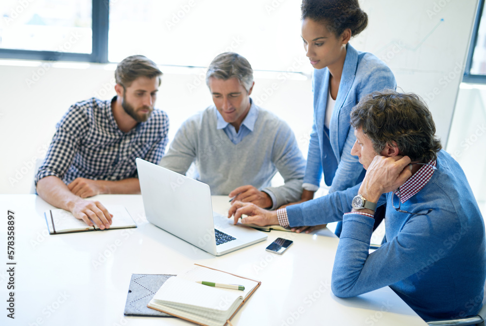 Obraz premium Technology makes brainstorming more efficient. A group of business colleagues discussing work on a laptop during a boardroom meeting.