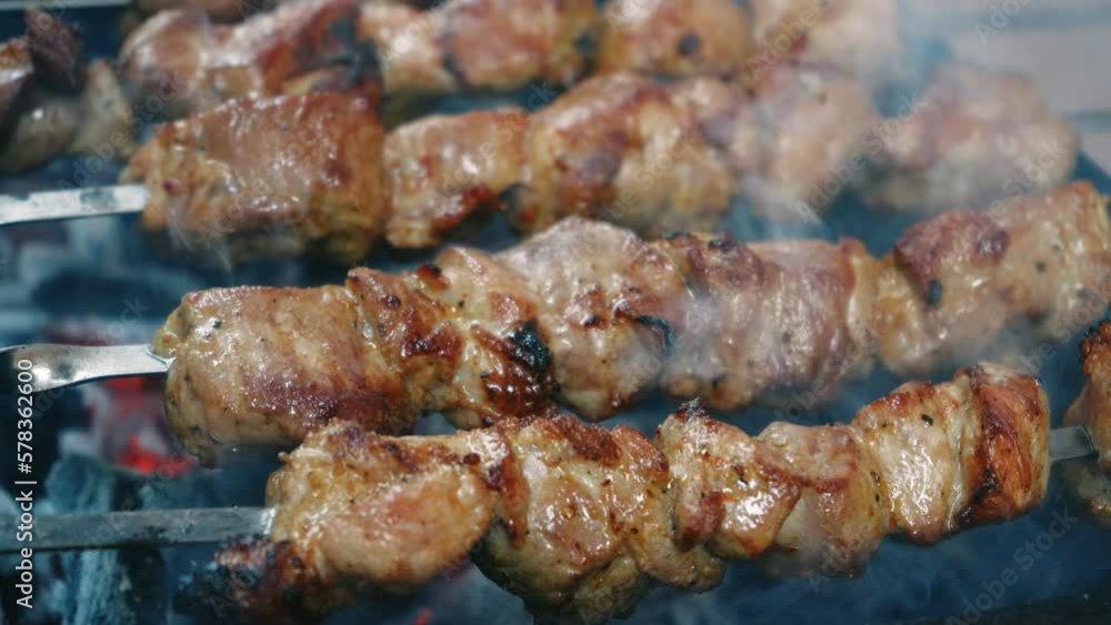 Close-up fries meat skewers. Barbecue on skewers. Barbecue grill. Leisure, food, people, holidays. Concept - a man cooks meat on a barbecue grill for his friends. Close-up fries meat skewers. Barbecue on skewers. Barbecue grill. Leisure, food, people, holidays. Concept - a man cooks meat on a barbecue grill for his friends.