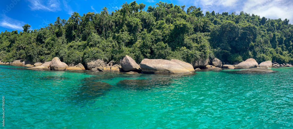 Paraty, Brazil. Blue Lagoon. Sea with clear turquoise water, rocks and diving spots. Tropical forest and blue sky.