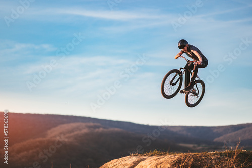 Fototapeta Naklejka Na Ścianę i Meble -  Young man flying through the air on a mountain bike