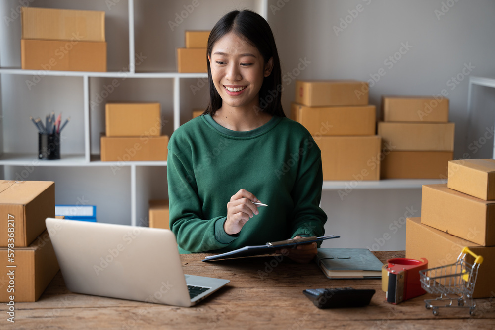 Small business entrepreneur SME owner checking customer details on packaging box preparing for delivery. Small business entrepreneur SME owner checking customer details on packaging box preparing for delivery.