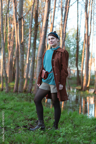 Young stylish beautiful woman in fashionable clothes standing in spring park. Springtime concept portrait © mariarom