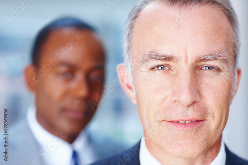 Senior executive with partner in distance. Closeup of Business man with man in background.