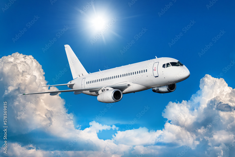 White passenger jetliner fly in the air above picturesque clouds White passenger jetliner fly in the air above picturesque clouds