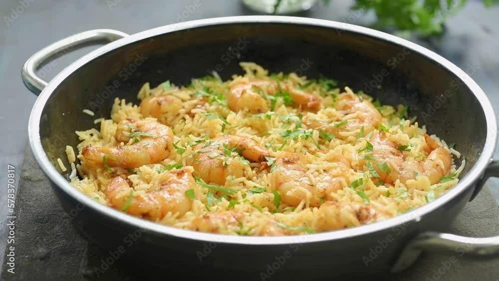 The cook serves shrimp with fried rice on the table.
The cook serves shrimp with fried rice on the table.