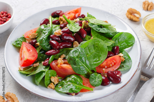 Red Bean Salad On Bright Background, Fresh Salad with Spinach, Cherry Tomatoes, Walnuts, Beans and Mustard Dressing