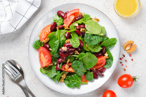 Red Bean Salad On Bright Background, Fresh Salad with Spinach, Cherry Tomatoes, Walnuts, Beans and Mustard Dressing