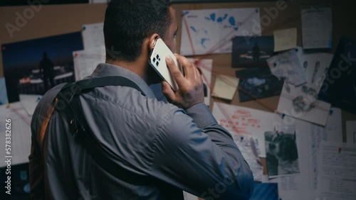 Wallpaper Mural Busy male detective talking on phone near crime evidence board in police office Torontodigital.ca