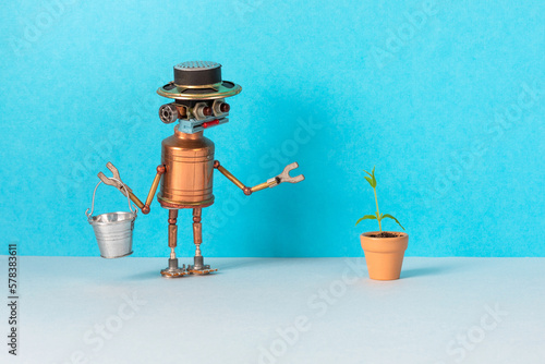 Obraz na płótnie Toy robot brought a bucket of water for a plant growing in a flower clay pot