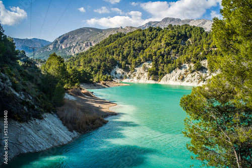 Lake Guadalest, rocky mountains and hills covered with trees. Blue sky © Piotr