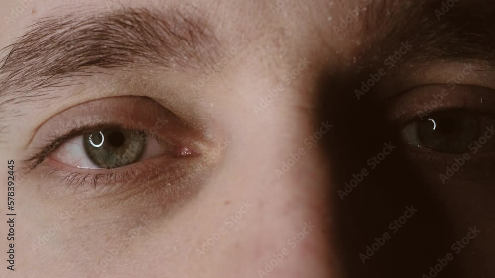Close-up of blinking green eyes. A young man opens and closes his beautiful eye. Close-up of blinking green eyes. A young man opens and closes his beautiful eye.