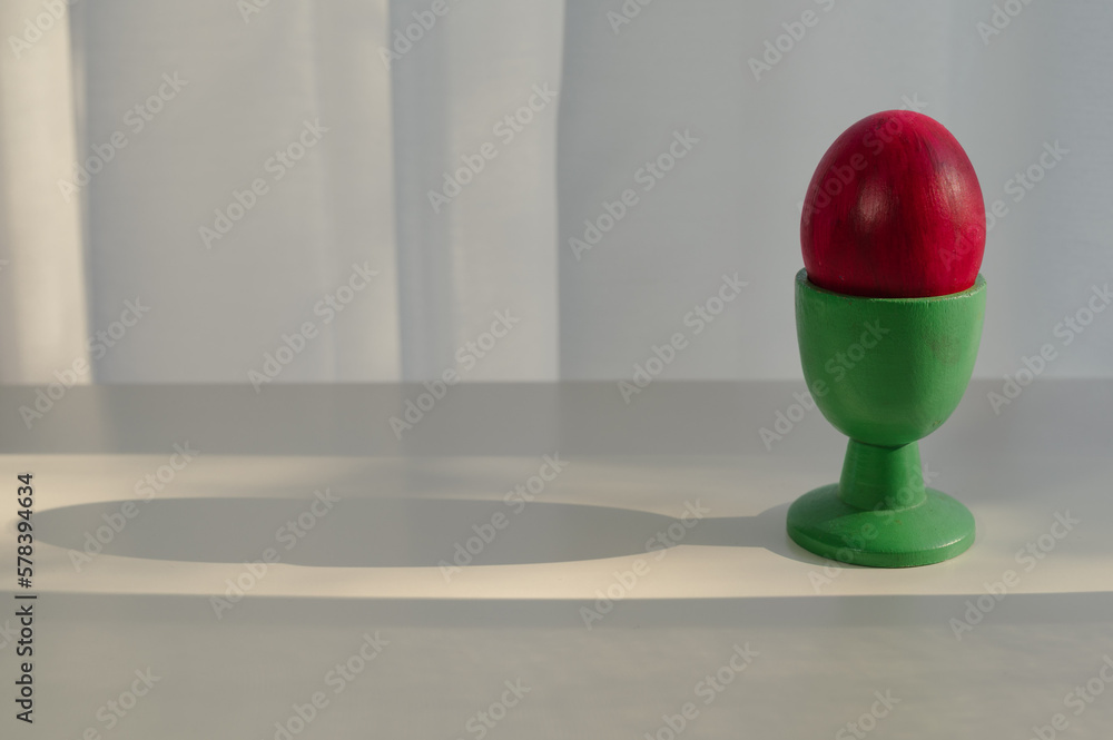 red colored easter egg on a table with shadow red colored easter egg on a table with shadow