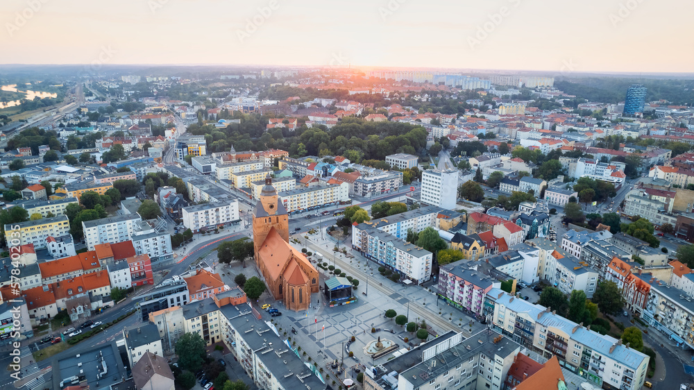 In Gorzów Wielkopolski, a drone photo was taken on a sunny day featuring the River Warta, the Cathedral, and the city center - obrazy, fototapety, plakaty 