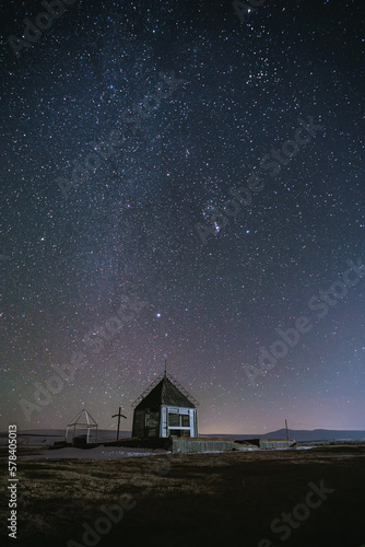 small wooden church in a field under a starry sky © vadimborkin