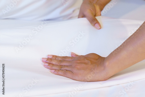 Obraz na płótnie Female Hand set up white bed sheet in bedroom or maid hands making bed in a hotel room w salonie