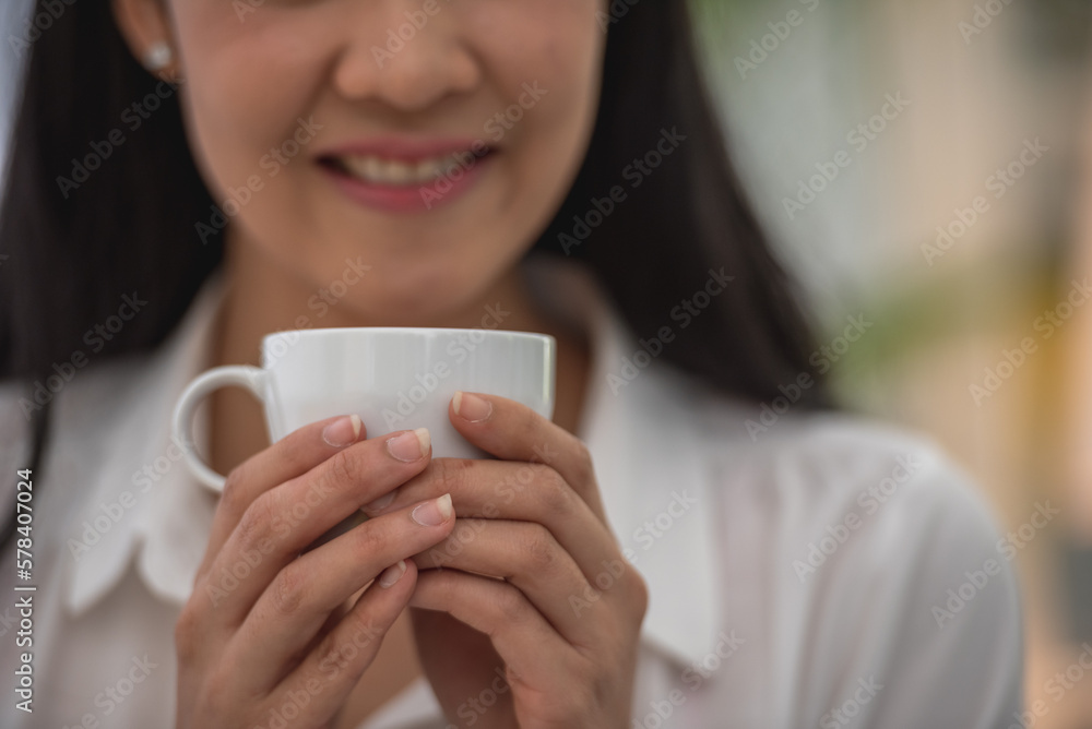 Banner of Asian woman Proprietor holding hot coffee in white ceramic cup to sniff smell of espresso in office work place . business owner entrepreneur girl carry coffee break to sniff fragrant smell Banner of Asian woman Proprietor holding hot coffee in white ceramic cup to sniff smell of espresso in office work place . business owner entrepreneur girl carry coffee break to sniff fragrant smell