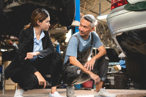 Asian woman customer talking with professional mechanic worker or workshop owner, client checking a maintenance job with garage automobile technician, business of car repair transportation service