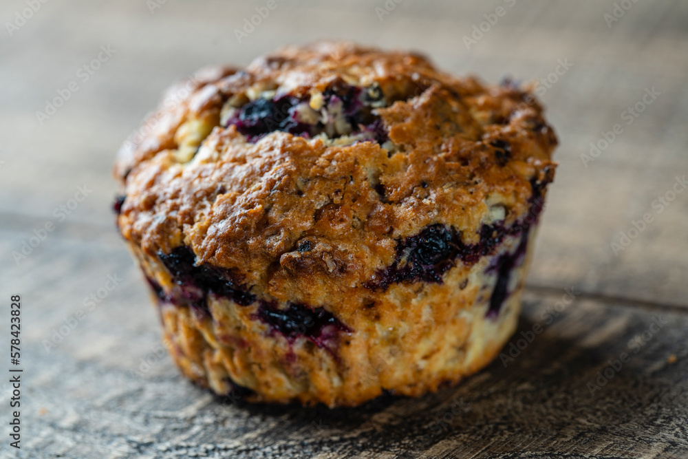 Delicious muffin with blueberries on a wooden table, closeup. Sweet pastries on the board. Fresh cupcake for breakfast Delicious muffin with blueberries on a wooden table, closeup. Sweet pastries on the board. Fresh cupcake for breakfast