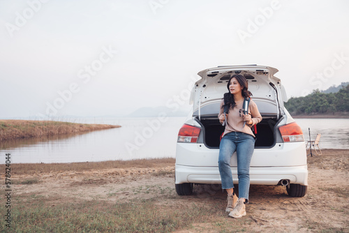 Backpacker asian woman standing backside of her car with backpack for camping road trip, Enjoying life and freedom on vacation, Adventure and travel concept.