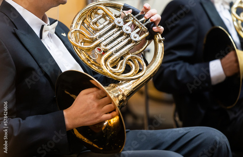 French horn instrument, hands playing horn player in philharmonic orchestra