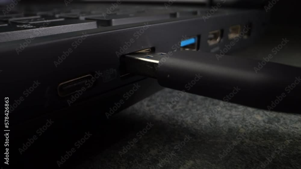 USB cable inserted into an old laptop. Close-up. Dolly shot USB cable inserted into an old laptop. Close-up. Dolly shot