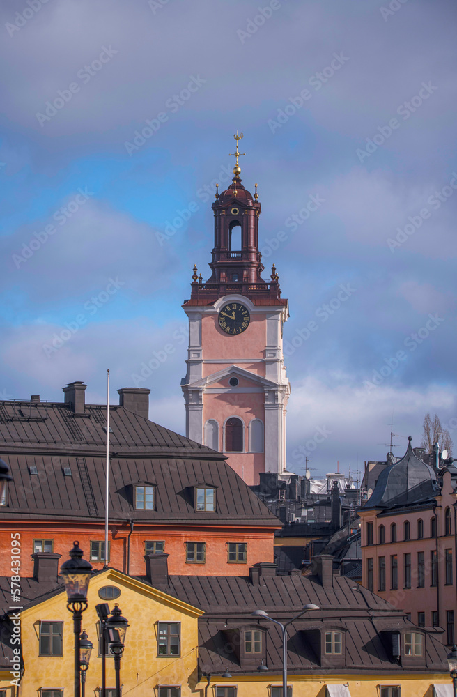 From the island Riddarholmen the tower of the renovated church Stor Kyrkan, roofs and facades in the old town Gamla Stan, a sunny spring day in Stockholm