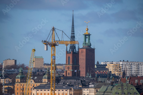 A crane, the tower of the church Riddarholms Kyrkan and the Town City Hall, roofs and facades in the old town Gamla Stan, a sunny spring day in Stockholm © Hans Baath