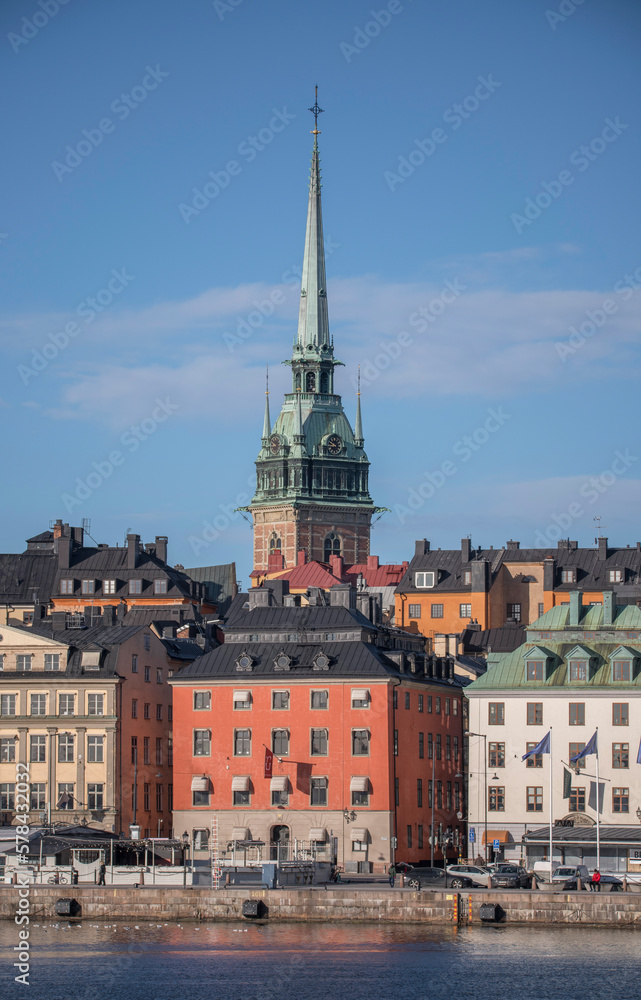 From east, the tower of the German church, roofs, facades and the pier Skeppsbron in the old town Gamla Stan, a sunny spring day in Stockholm