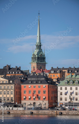 From east, the tower of the German church, roofs, facades and the pier Skeppsbron in the old town Gamla Stan, a sunny spring day in Stockholm