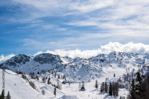 Lots of skiers and snowboarders on the slope at ski resort