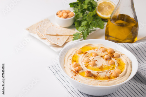Hummus in a plate with chickpeas, smoked paprika, olive oil and pita. Vegetarian food.