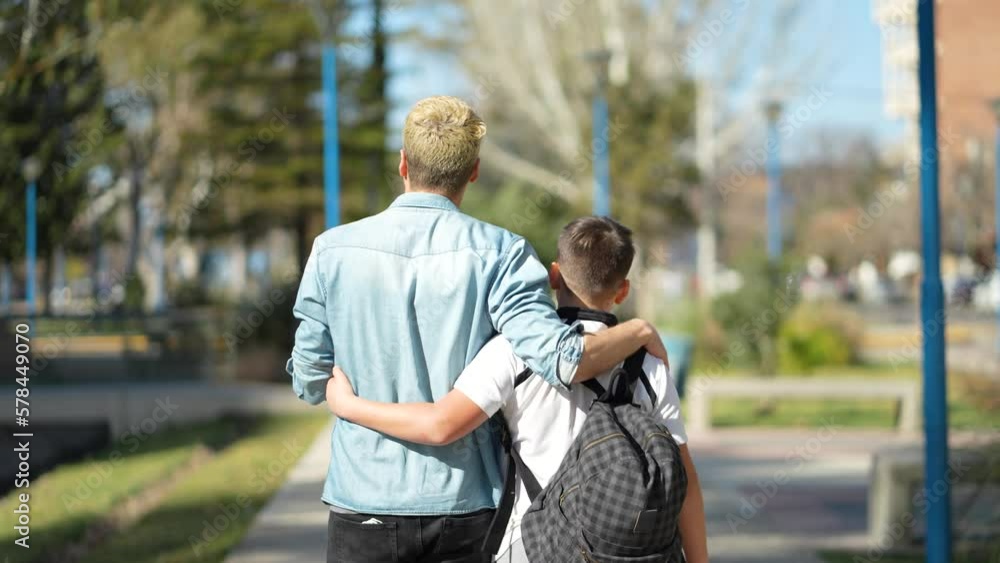 Father and son embracing each other while walking to school. Father and son embracing each other while walking to school.