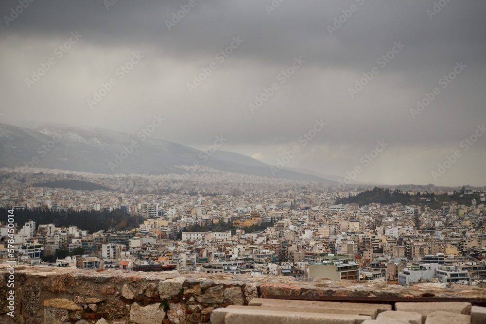 View on Athens streets from Pantheon on winter during cloudy cold day with snow on the mountain in background