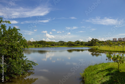 Uma paisagem do Parque Leol  dio di Ramos Caiado na cidade de Goi  nia com um pequeno lago e vegeta    o verde e fresca.